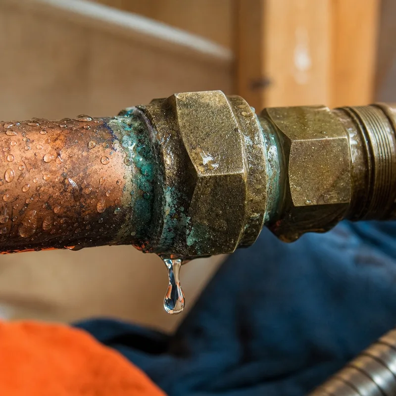 Corroded copper compression fitting with water droplets forming